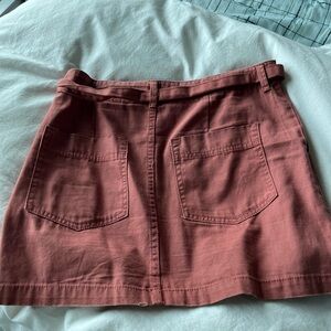 Medium rose colored skirt with two pockets and a belt